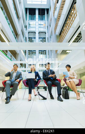 Business-Leute sitzen in Bürogebäude Stockfoto