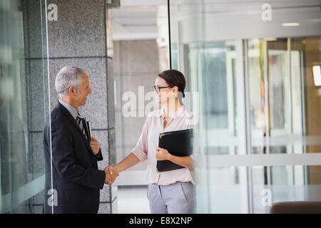 Geschäftsleute Händeschütteln im Bürogebäude Stockfoto