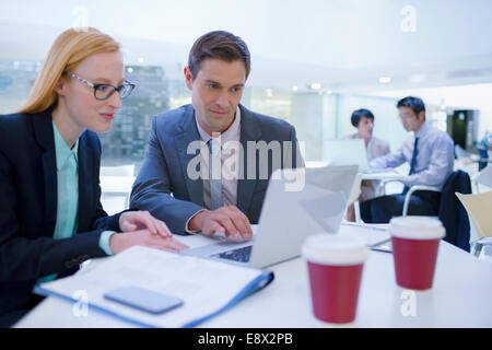 Geschäftsleute auf Laptops am Tisch Stockfoto