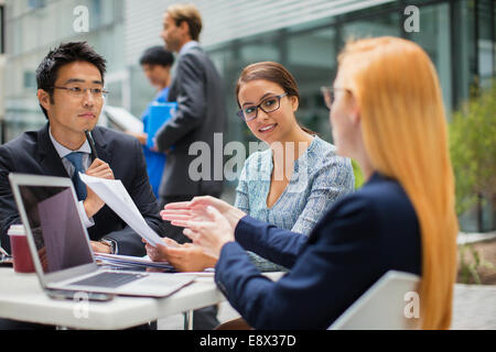 Geschäftsleute sprechen am Gartentisch Stockfoto