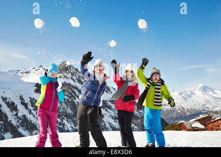 Familie werfen Schneebälle auf Berggipfel Stockfoto