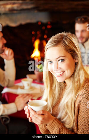 Frau hält heißes Getränk im restaurant Stockfoto