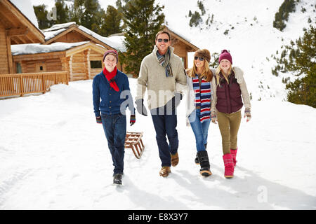 Familie, die zusammen durch den Schnee spazieren Stockfoto