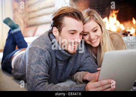 Paar mit digital-Tablette Kamin zusammen Stockfoto