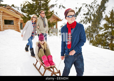 Bruder Schwester auf Schlitten im Schnee ziehen Stockfoto