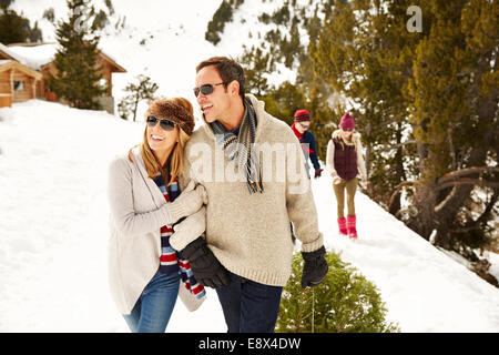 Paare, die durch Schnee zusammen Stockfoto