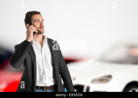 Geschäftsmann am Telefon mit Autos hinter ihm Stockfoto