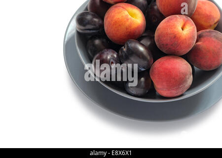Köstliche frische Pflaumen und Pfirsiche isoliert auf weißem Hintergrund. Stockfoto