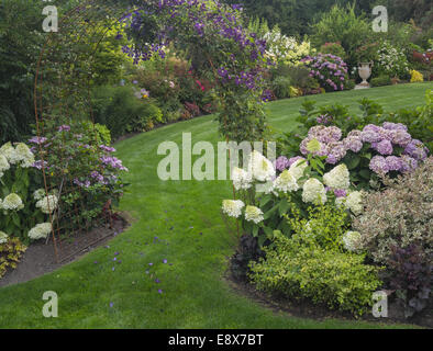 Maury-Vashon Island, WA: Rasen Weg mit Spalier im Sommergarten Stockfoto