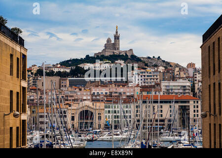 Notre Dame de la Garde Basilika auf einem Hügel zwischen zwei Gebäuden, Marseille Stockfoto