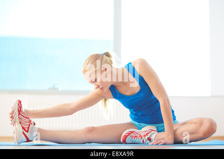 Sportliche Frau in Activewear tun stretching-Übung im Fitnessstudio Stockfoto