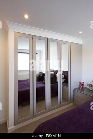 Ein geschlossener Schrank mit klappbaren Spiegeltüren in einem Schlafzimmer in einem Haus im Vereinigten Königreich. Stockfoto