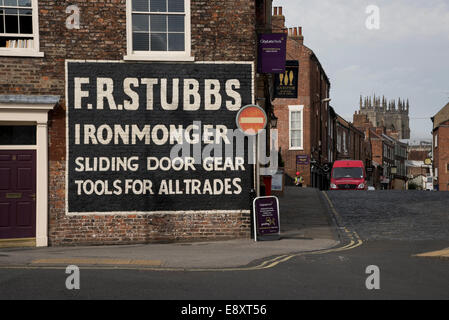 Große, klare Handbemalte ghost Zeichen, eine alte Werbung für ein eisenhändler, an der Seite eines Gebäudes - York, North Yorkshire, England, UK. Stockfoto