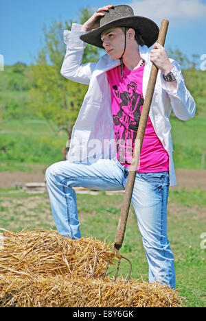 junger Mann auf Heuballen Stockfoto