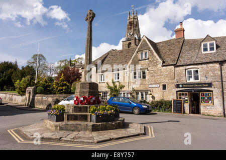 Traditionelle Cotswold Steinbauten mit Holy Trinity Church im Hintergrund, Minchinmapton, Gloucestershire Stockfoto