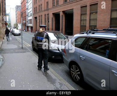 Manchester, UK. 16. Oktober 2014.  Ein Parkplatz-Wächter prüft Autos auf Lloyd Street, wo über 1700 Parkplätze Tickets für illegales Parken von 2008 bis 2013, die vierte ausgestellt wurden für jede Straße in Greater Manchester am höchsten. Bildnachweis: John Fryer/Alamy Live-Nachrichten Stockfoto