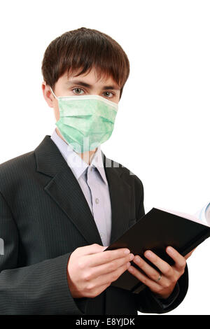 Teenager in einer Schutzmaske mit einem Buch Stockfoto