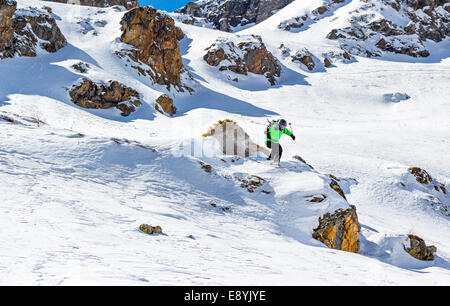 Frau Skifahrer Sprung von einer Klippe in den Bergen an einem sonnigen Tag Stockfoto