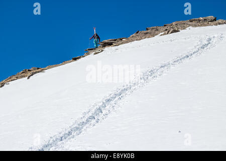 Skifahrer aus Steinen auf dem Hintergrund einer klaren Himmel Aufstieg bergauf entlang des Weges im Schnee Stockfoto