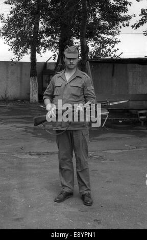 Region Moskau, Russland - ca. 1993: einen Soldaten mit Gewehren posieren. Film scannen. große Körner, ca. 1993 Stockfoto