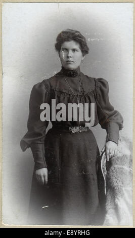 BERLIN, Deutschland - CIRCA 1905: Ein Vintage Porträt einer Frau, in der Nähe von dem Stuhl stehend und gekleidet in einem Kleid, ca. 1905 Stockfoto