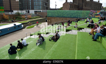 London UK. 16. Oktober 2014. Essen Sie auf einen warmen Herbst nachmittags Menschen Mittagessen von Straßenküchen vans Astroturf STUFENPLATZ UAL Universität der Künste in Kings Cross Regents Canal.  KATHY DEWITT/Alamy Live-Nachrichten Stockfoto