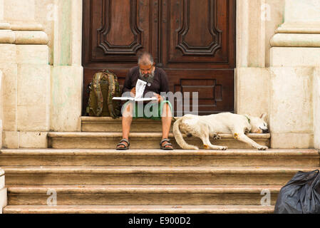 Portugal Lissabon Chiado Largo Chado Kirche Schritte bärtigen älteren Mann in grünen Shorts mit weißen Hund Rucksack Buch Stockfoto