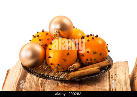 Weihnachten-Orange und Kugeln mit Zimtstangen auf Brennholz auf weißem Hintergrund Stockfoto