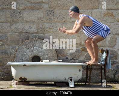 Mann in Retro-Badeanzug springt an der Badewanne im freien Stockfoto