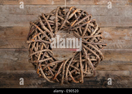 Runde braune Adventskranz aus natürlichen Zweige auf alten hölzernen rustikalen Hintergrund Stockfoto