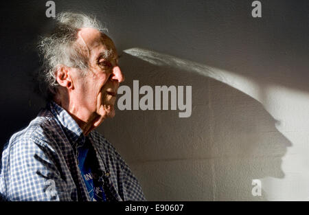 Ein älterer Mann wirft einen langen Schatten beim Anhören von Musikkonzert Stockfoto