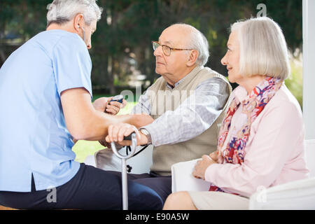 Männlicher Arzt Blutdruck messen Der älteren Mann Stockfoto