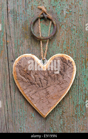 Herz aus Holz auf Baumrinde als Symbol für die Liebe Stockfoto