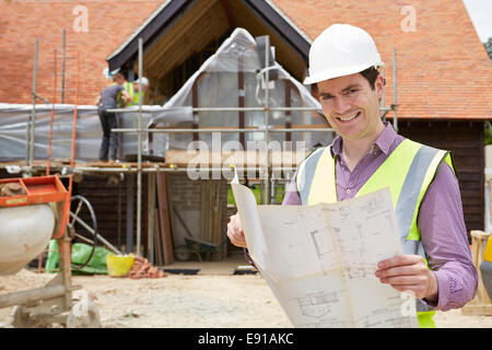 Architekten auf der Baustelle betrachten Hauspläne Stockfoto