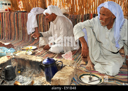 Zwei Beduinen Männer kochen Mahlzeit in der Wüste über Feuer in Unterschlupf bei Ain Hudra (oder Ayun Khodra) Oase Stockfoto
