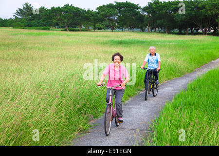 Glücklich asiatischen Senioren paar Biken in den park.retirement und gesunden Lifestyle-Konzept Stockfoto