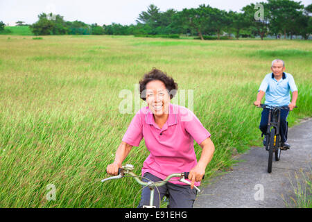 Glücklich asiatischen Senioren paar Biken in den park.retirement und gesunden Lifestyle-Konzept