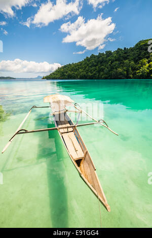 Traditionelles Boot schwimmt auf den transparenten der entfernten Togean (oder Togian) Inseln, Zentral-Sulawesi, Indonesien. Stockfoto