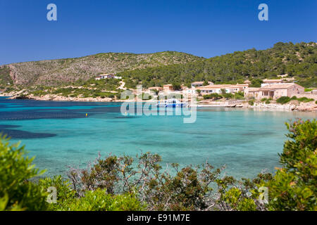 Insel Cabrera, Mallorca, Balearen, Spanien. Blick über Bucht, direkt am Wasser Häuser, Boot am Kai. Stockfoto