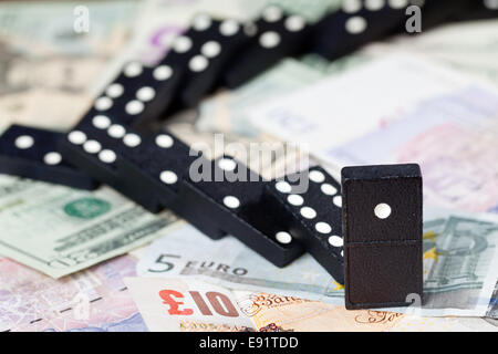 Gefallenen Dominos auf Banknoten Stockfoto