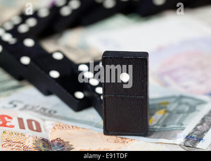 Gefallenen Dominos auf Banknoten Stockfoto