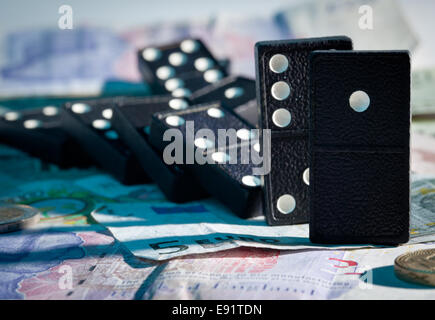 Gefallenen Dominos auf Banknoten Stockfoto