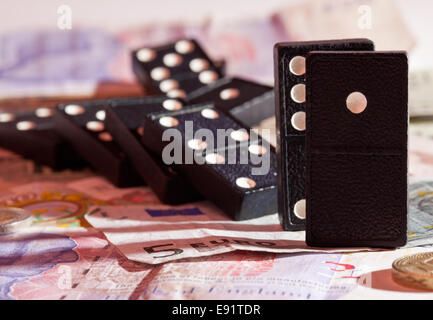 Gefallenen Dominos auf Banknoten Stockfoto