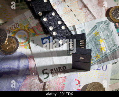 Gefallenen Dominos auf Banknoten Stockfoto