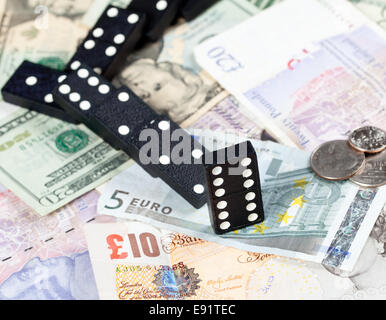 Gefallenen Dominos auf Banknoten Stockfoto