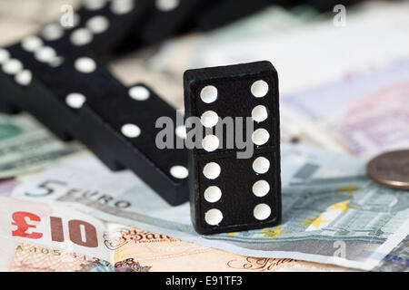 Gefallenen Dominos auf Banknoten Stockfoto