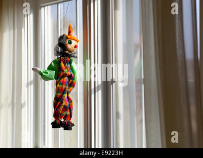 Zeichenfolge, die Marionette Blick aus Fenster in Sonne Stockfoto