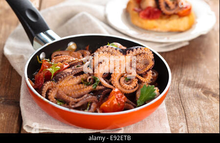 Italienisches Essen. Baby-Tintenfische mit Tomaten, Knoblauch und Petersilie zubereitet. Stockfoto