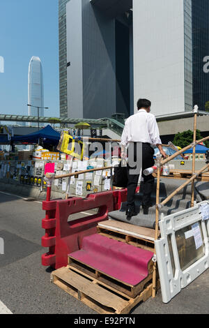 Hong Kong. 17. Oktober 2014. Proteste: Studenten, pro-Demokratie-Aktivisten und anderen Unterstützern der Occupy Central, jetzt genannt den Regenschirm-Bewegung oder den Regenschirm-Revolution bleiben der Tamar Protest-Webseite auch als Dach Platz. Ein Mann betritt den Bereich auf improvisierte Treppe Stockfoto