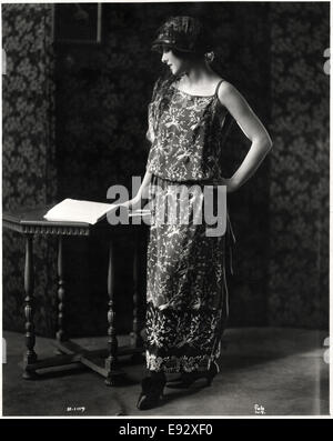 Modische Frau in Abendessen Kleid Seide Crepe und Satin mit bestickten Design tropische Vögel und Hut, Portrait, ca. 1922 Stockfoto